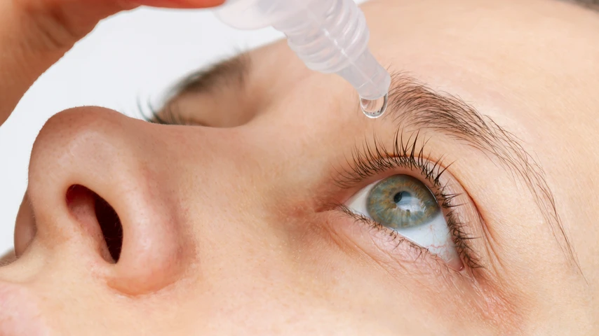 Woman applying eyedrops